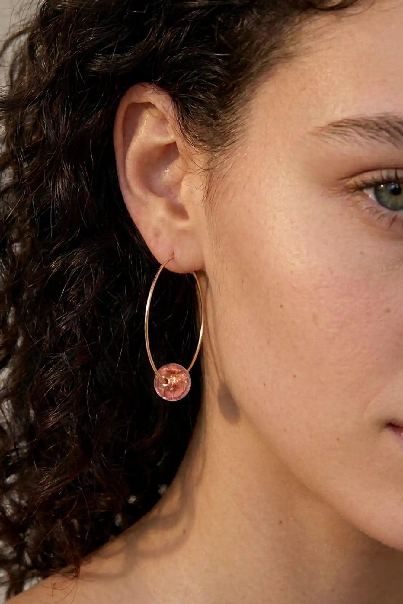 femme avec boucles d'oreilles créoles