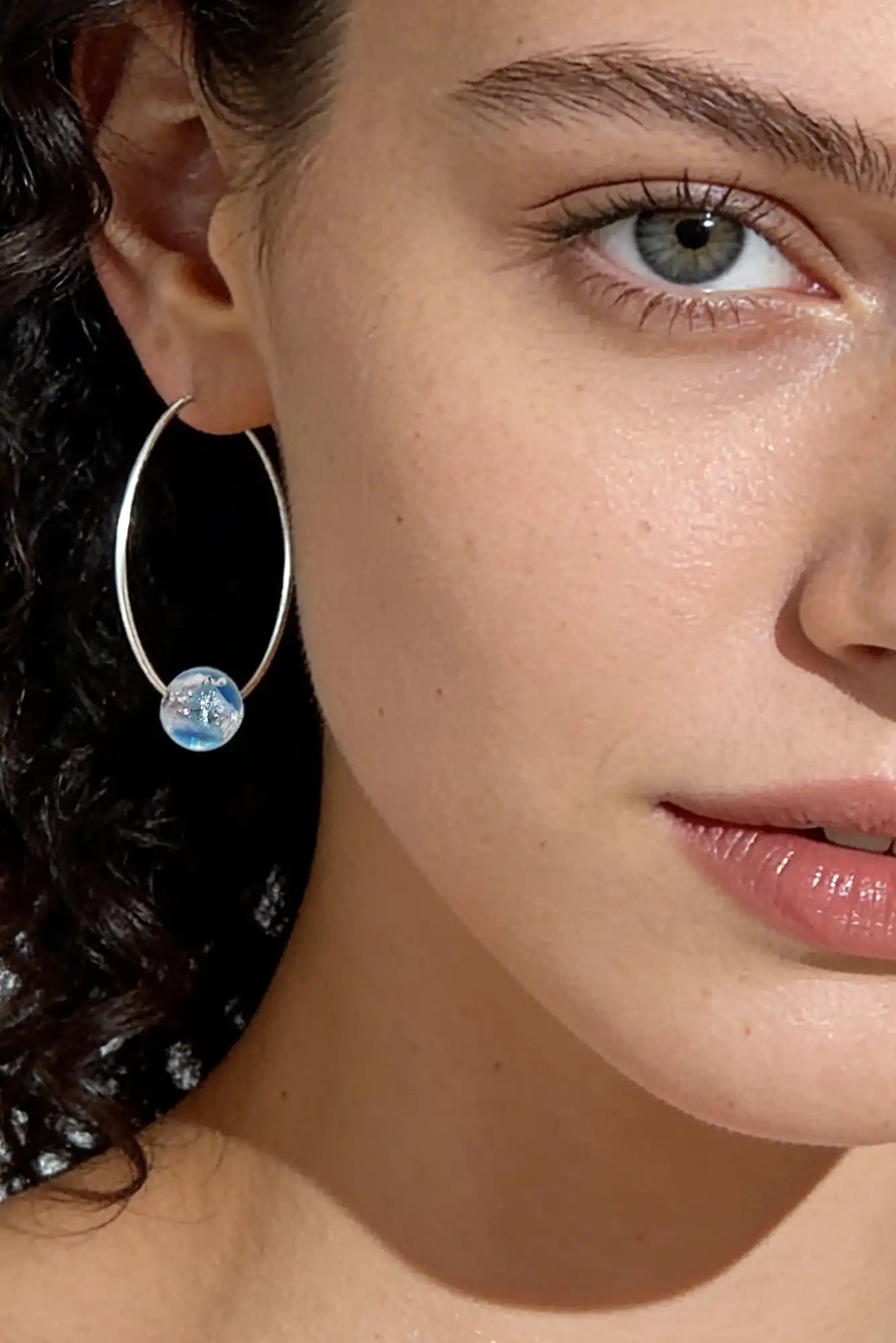 femme avec boucles d'oreilles murano
