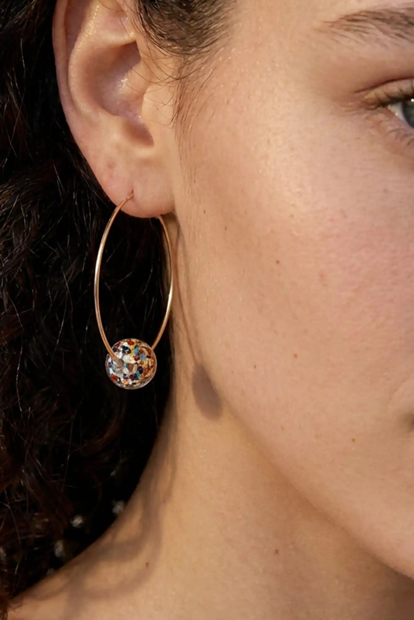 femme avec boucles d'oreilles créoles