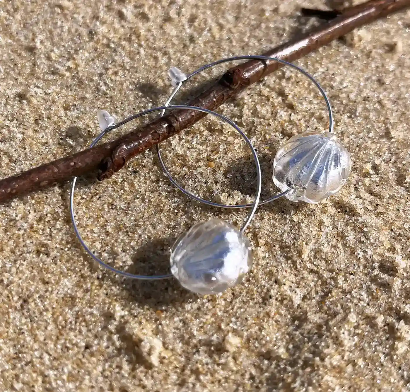 boucles d'oreilles créoles posées sur le sable