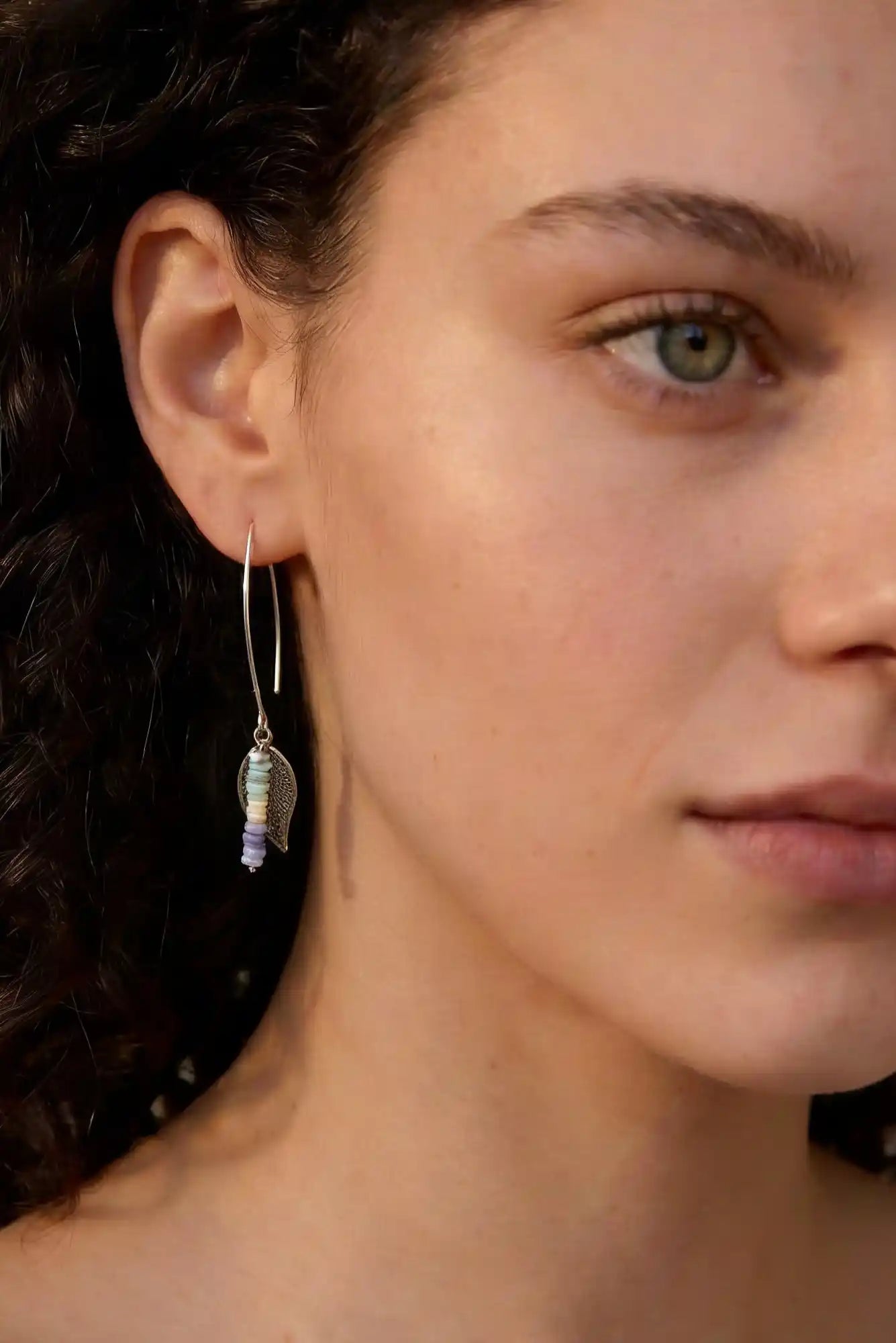femme avec boucles d'oreilles perles