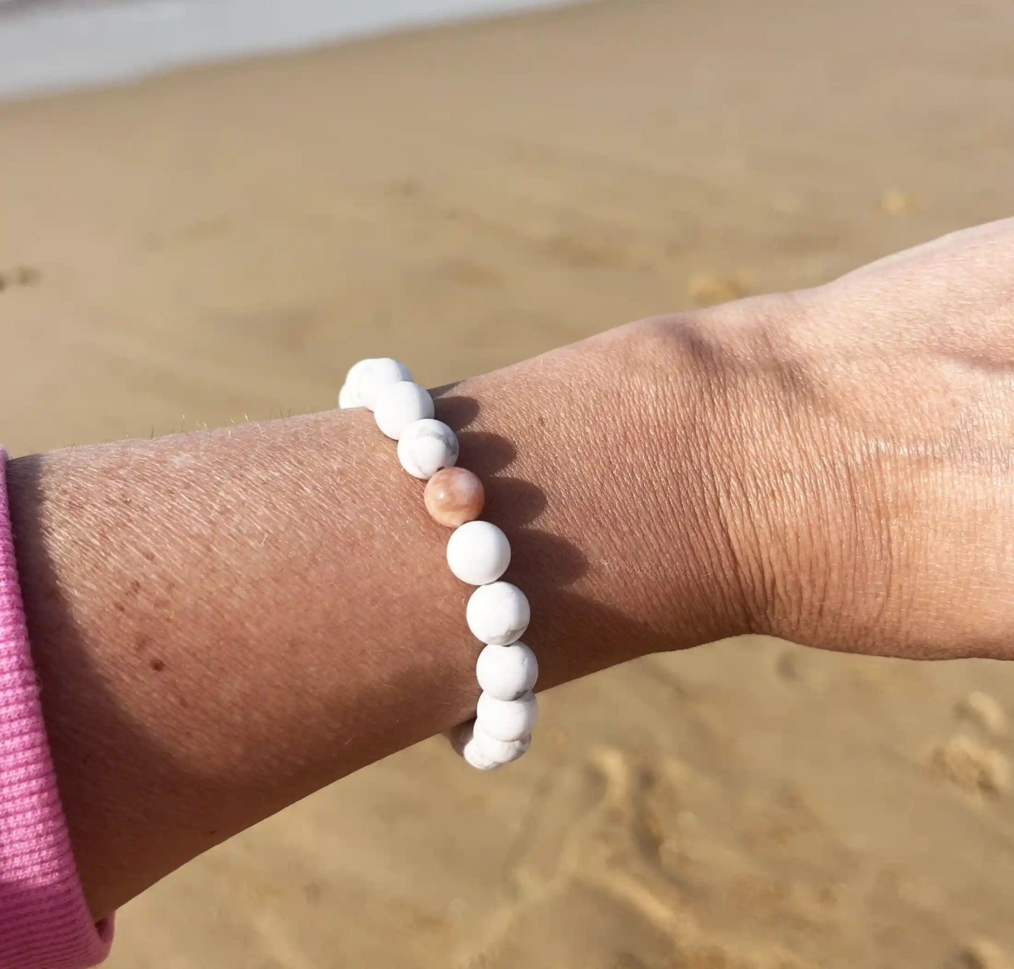 bracelet de perles blanche avec une perle rouge 