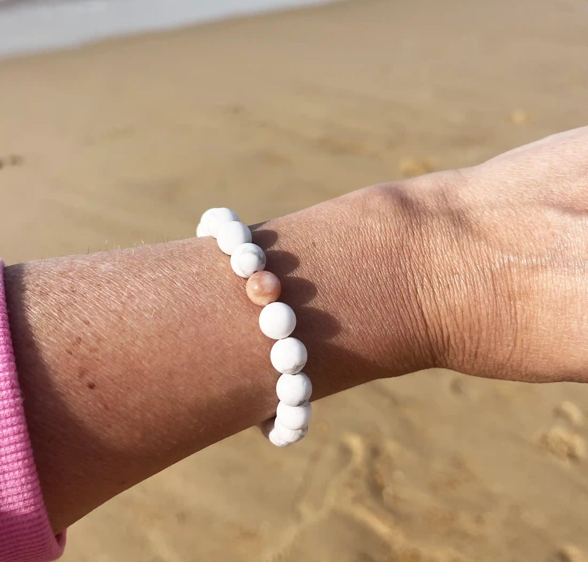 bracelet de perles blanche avec une perle rouge 